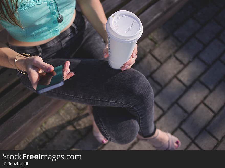 Woman Holding White Disposable Cup and Smartphone