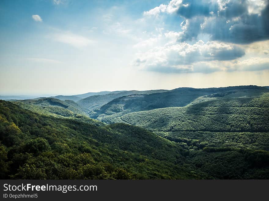 Green Tree Coated Mountain Under White and Blue Cloudy Sky at Daytime