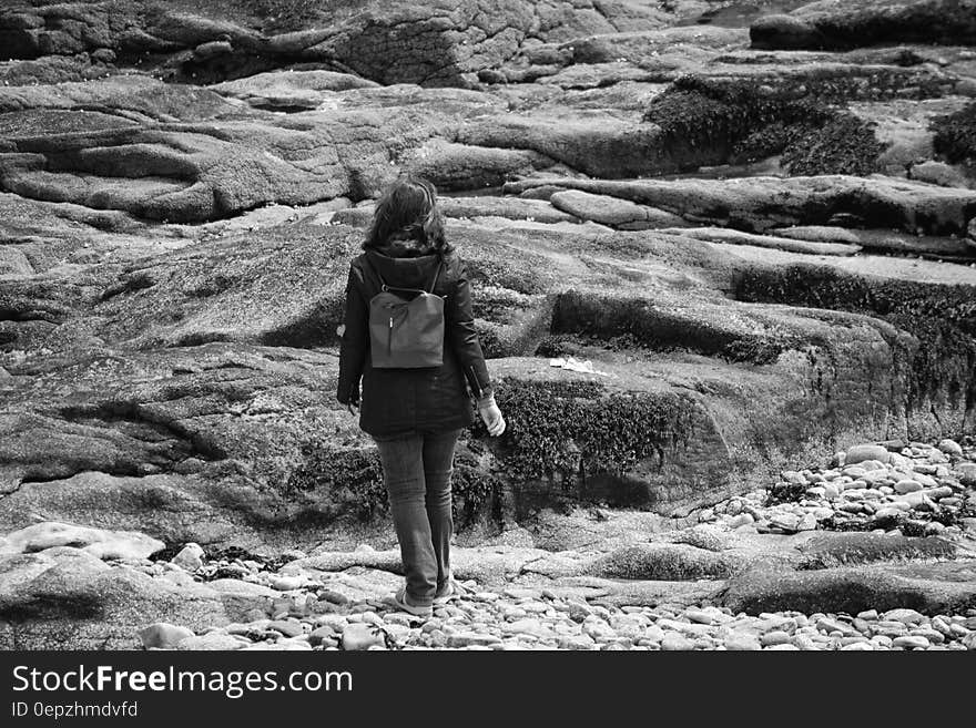 Gray Scale Woman in Black Hoodie Jacket on Concrete Rock