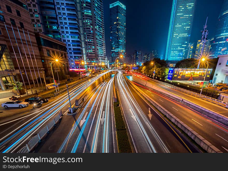 Timelapse Photography of Vehicle on Concrete Road Near in High Rise Building during Nighttime