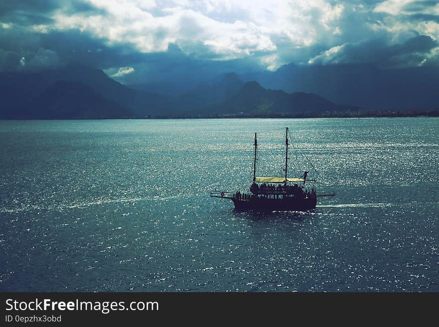 Sailboat Sailing Near Mountains Under Cloudy Sky