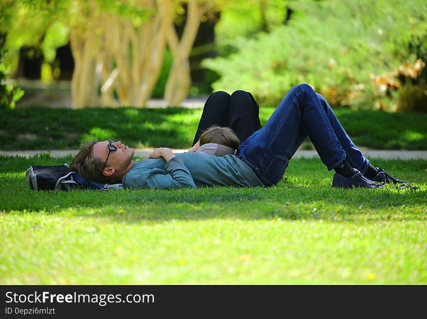 Man Wearing Blue Long Sleeve Shirt Lying on Ground during Daytime