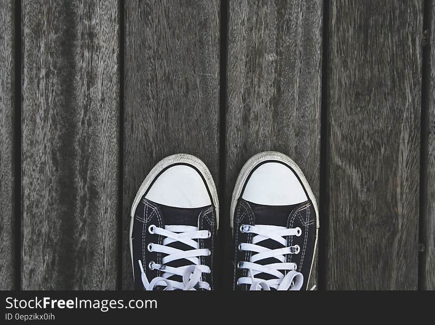 Black and White Sneakers on Grey Wooden Wood