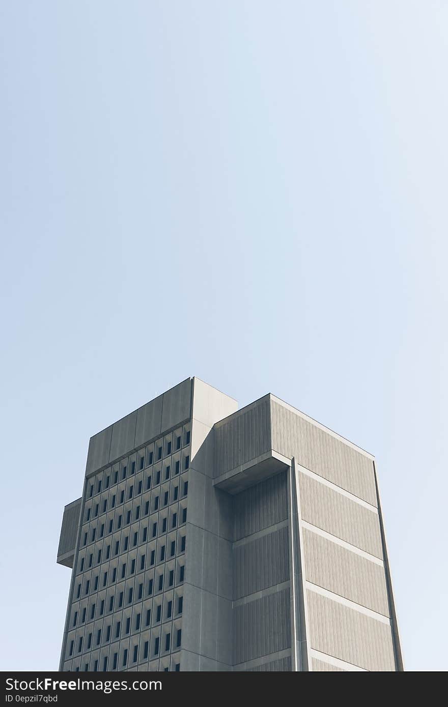 Exterior of modern skyscraper against blue skies on sunny day.