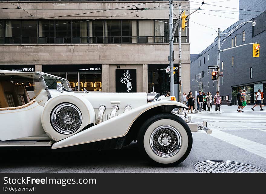 White Vehicle Near Gray Lamp Post and Brown Building Structure