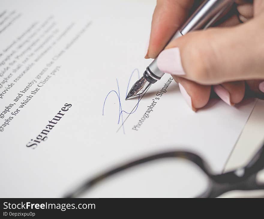 Person Holding Silver Pen Signing Photographers Signature