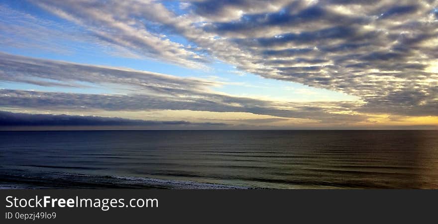 White Sky Under Blue Sea during Dawn