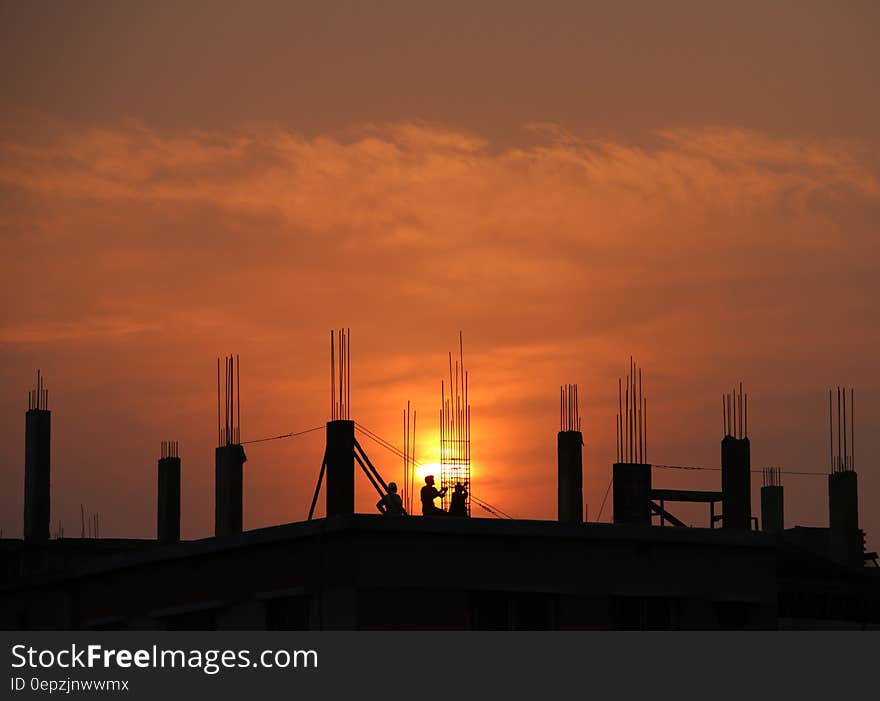 Silhouette of Men in Construction Site during Sunset