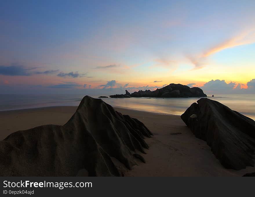 Island on Sea Under Blue Sky at Golden Hour