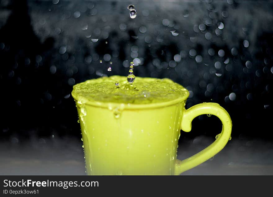 Yellow Ceramic Mug With Water Droplets in Time Lapse Photography