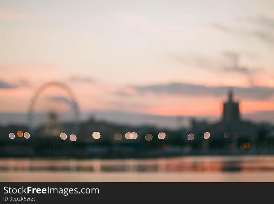 Blur of amusement park on horizon at sunset reflecting in waterfront. Blur of amusement park on horizon at sunset reflecting in waterfront.