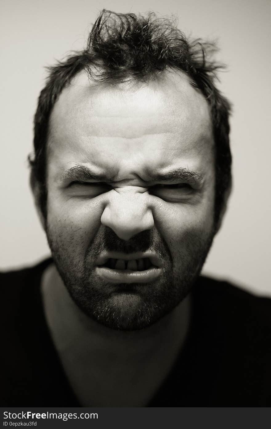 Black and white portrait of angry man grimacing.