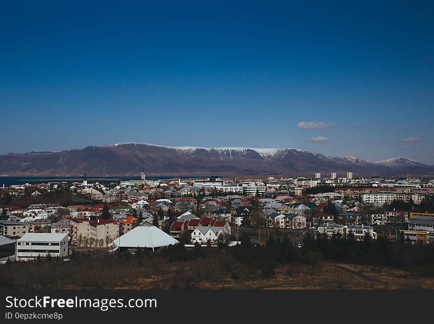 Scenic view of Icelandic town with snow capped mountains in background.