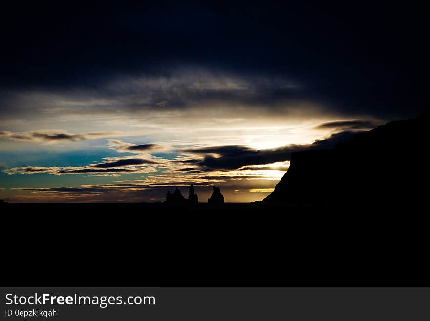 Dark clouds at sunset over a dark landscape. Dark clouds at sunset over a dark landscape.