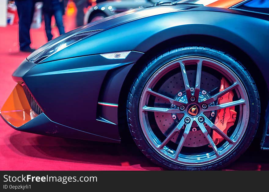 Close up of tire and front of blue Lamborghini sports car inside showroom. Close up of tire and front of blue Lamborghini sports car inside showroom.