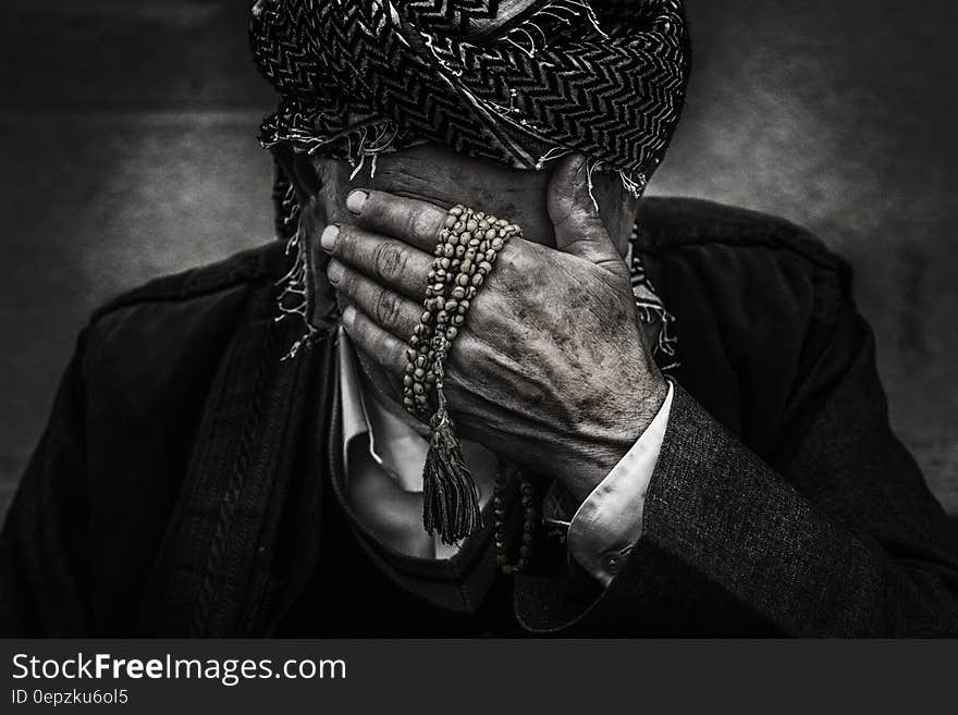 An old man with a turban hiding his face. An old man with a turban hiding his face.