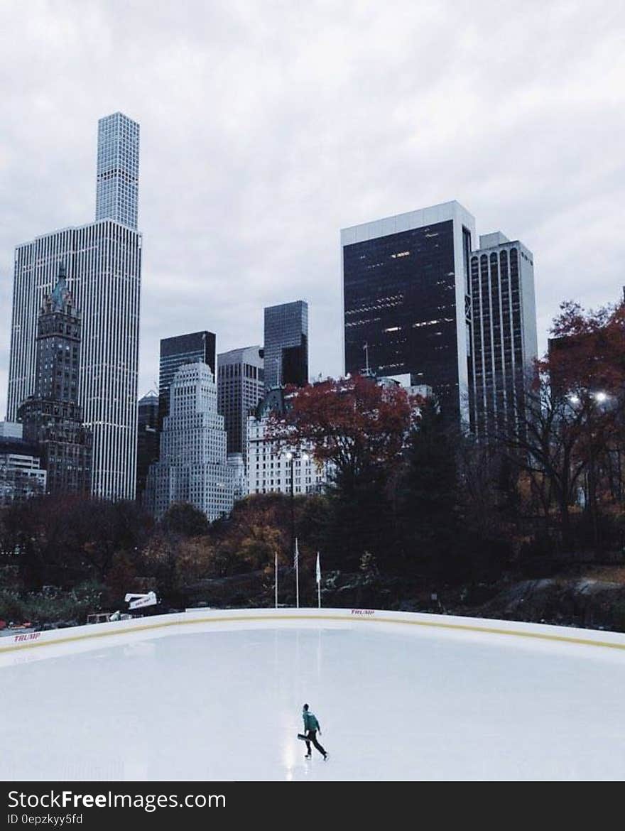 Lone Person Ice Skating Under Heavy Clouds