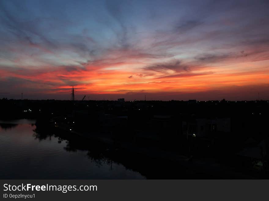 Silhouette Photo of Skyline Building Below Orange and Blue Sky