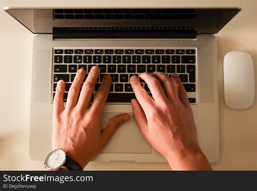 Overhead view of person typing on laptop computer.