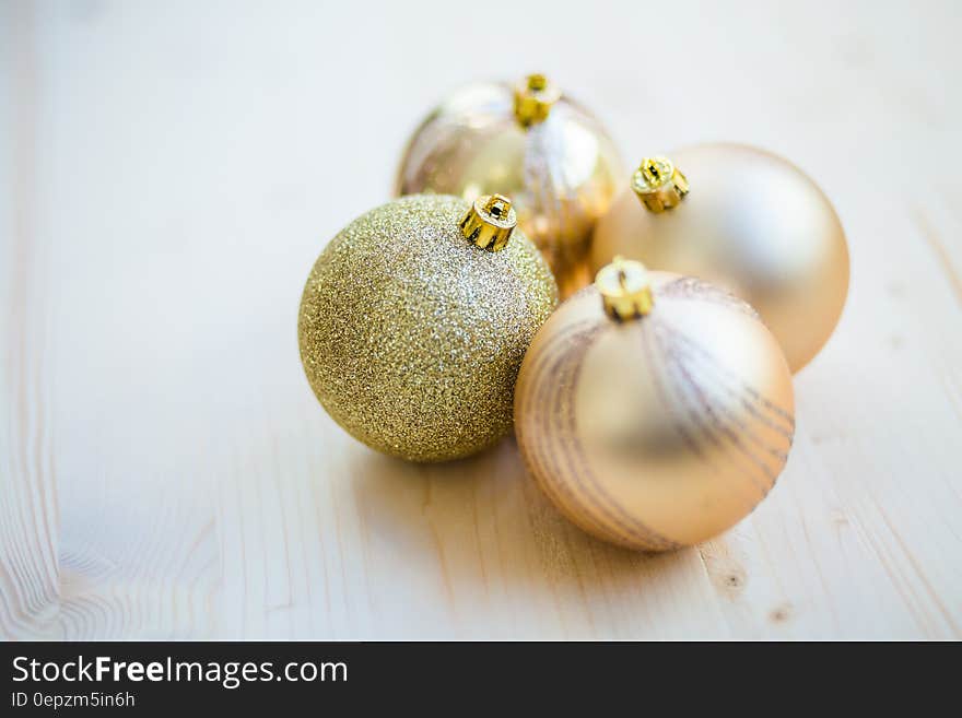 4 Christmas Baubles on Beige Wooden Flooring