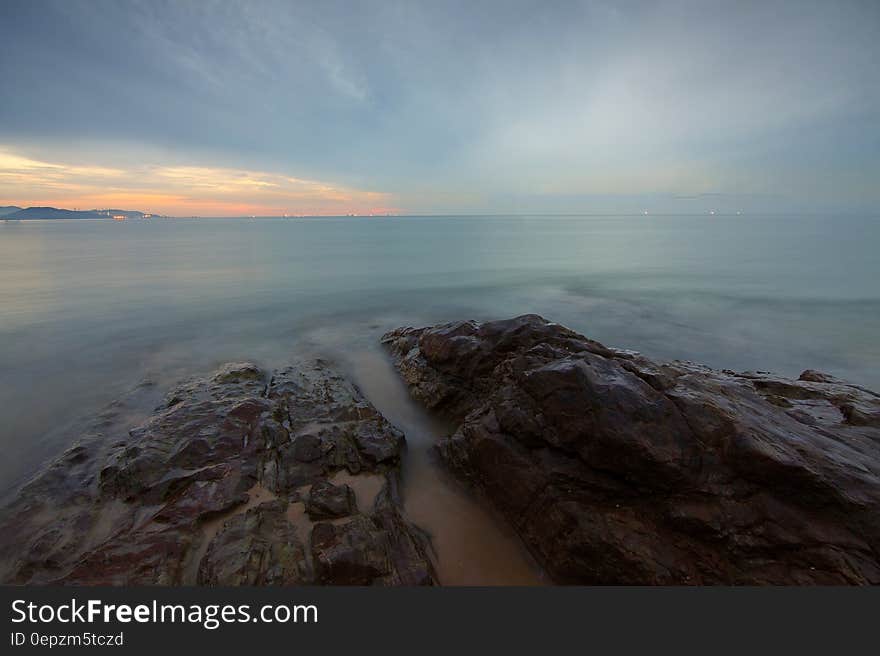 Rock Formation Surrounded by Sea during Daytime