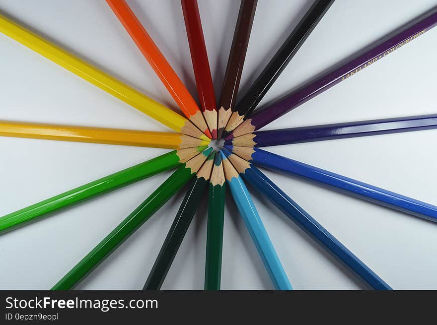 Colorful pencils set in formation with the tips pointing at each other.