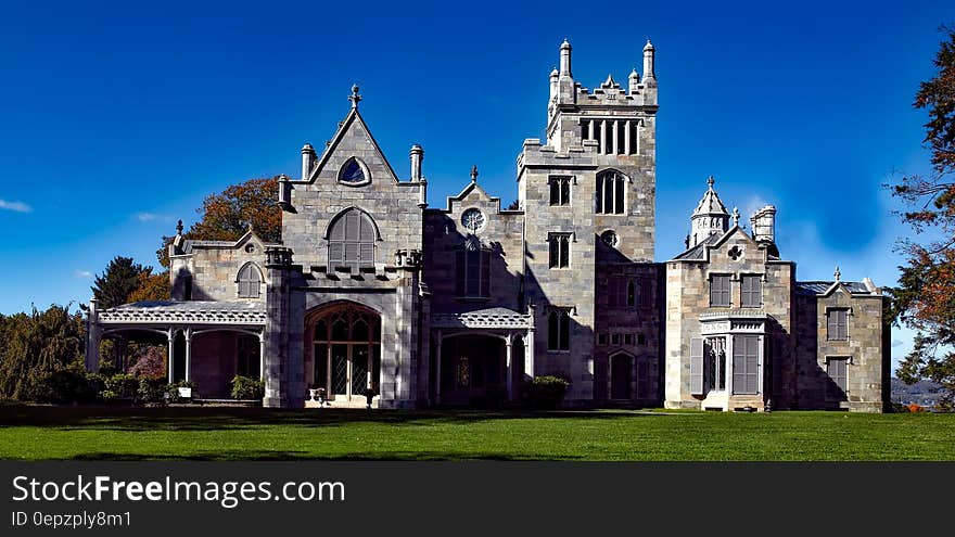 Exterior of mansion on green lawn against blue skies on sunny day in New York, USA. Exterior of mansion on green lawn against blue skies on sunny day in New York, USA.