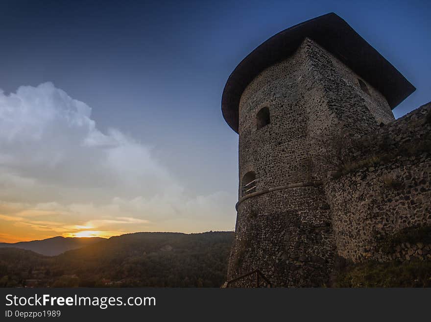 Photograph of Brown Temple Near Mountains during Sunset