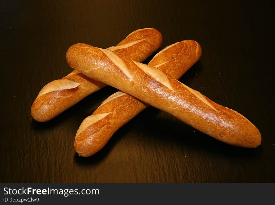 Loaves of crusty french baguettes on wooden table. Loaves of crusty french baguettes on wooden table.