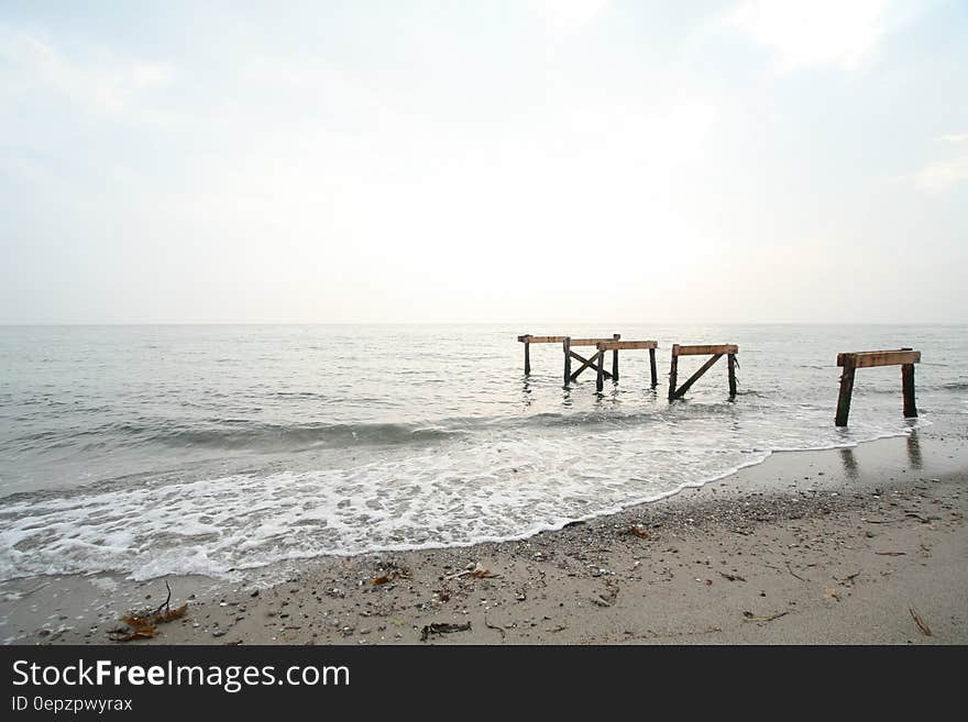 Wooden piles on sandy coastline on sunny day. Wooden piles on sandy coastline on sunny day.