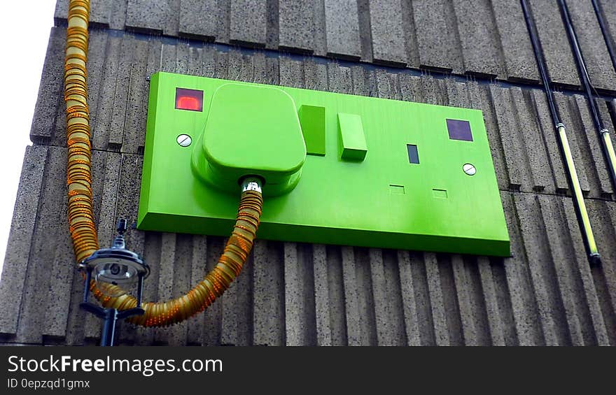 Green Rectangular Corded Machine on Grey Wall during Daytime