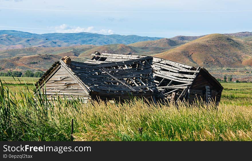 Brown Wooden House on Field Near Mountain during Daytime