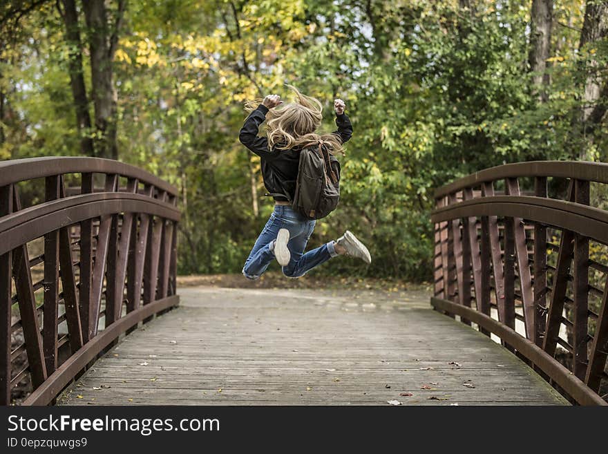 Girl Jumping on the Bridge Wearing Black Jacket