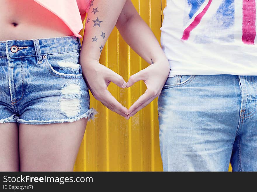 A man and a woman making a heart shape with their hands. A man and a woman making a heart shape with their hands.