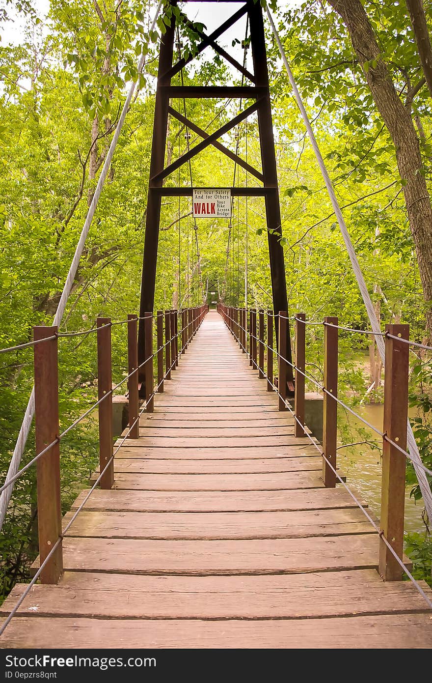 Wooden bridge in tree tops over sunny river. Wooden bridge in tree tops over sunny river.