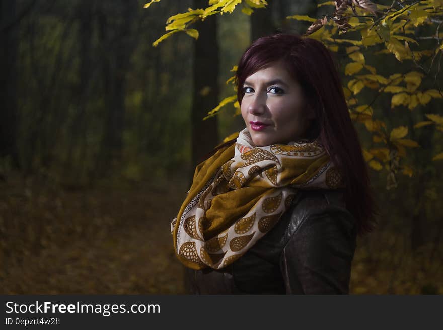 Woman Wearing Brown and White Scarf Surrounded by Trees at Daytime