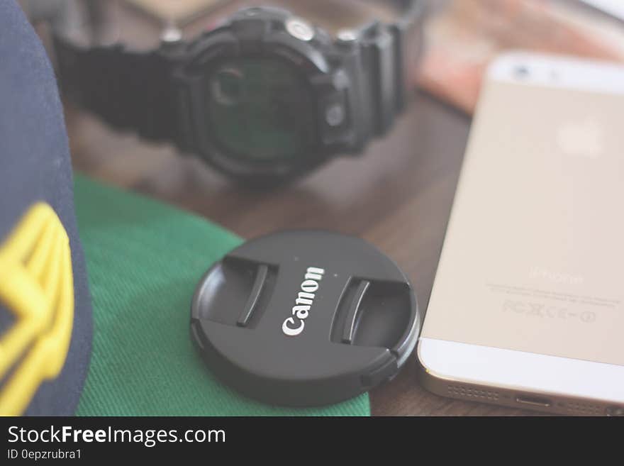 Canon Lens Cover Beside Gold Iphone 5s and Casio G Shock Chronograph Watch