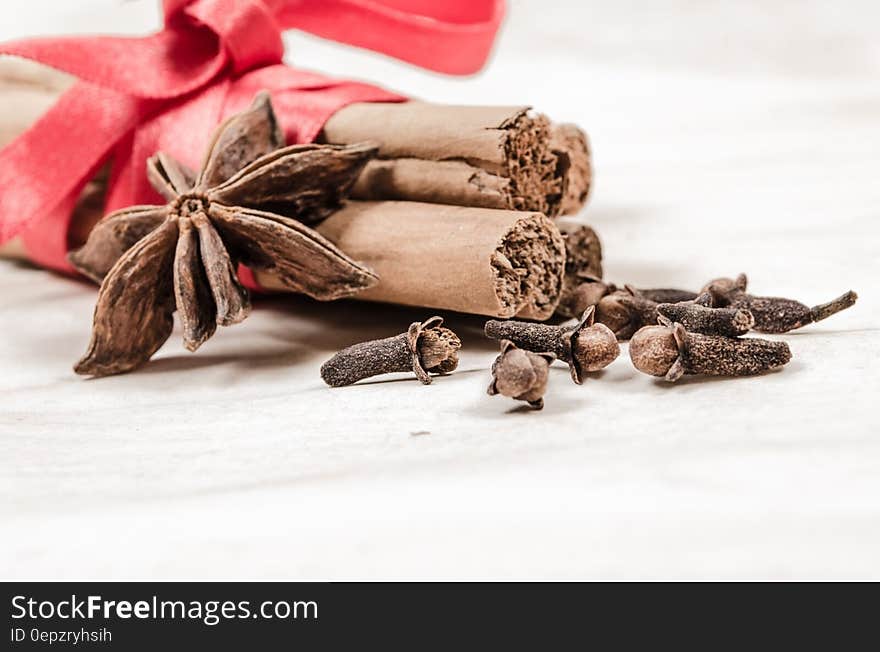 Cinnamon, star anise and cloves wrapped in red ribbon. Cinnamon, star anise and cloves wrapped in red ribbon.