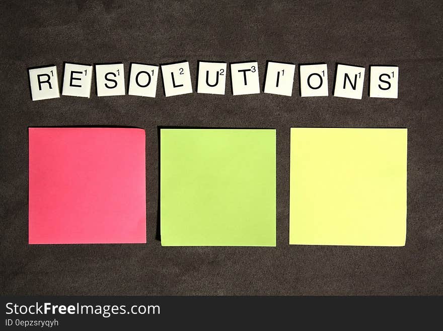 Resolutions spelled with Scrabble tiles with colorful post it notes.