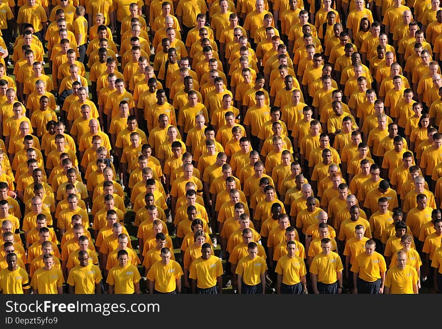 Navy personnel standing in formation in yellow shirts. Navy personnel standing in formation in yellow shirts.