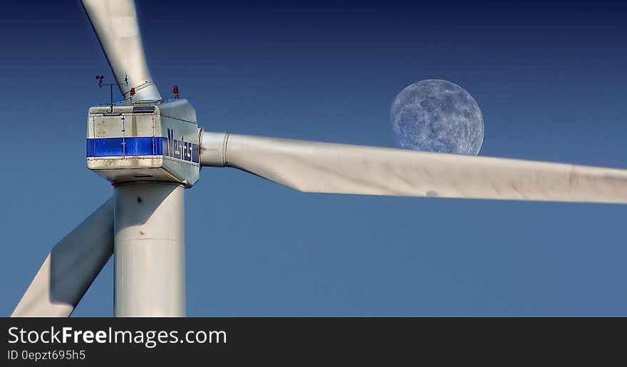 Close up of blades on wind turbine against blue skies on sunny day.