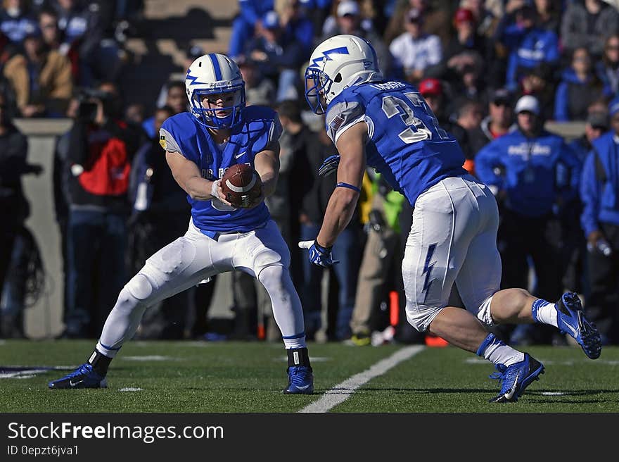 Football players on field during game on sunny day. Football players on field during game on sunny day.