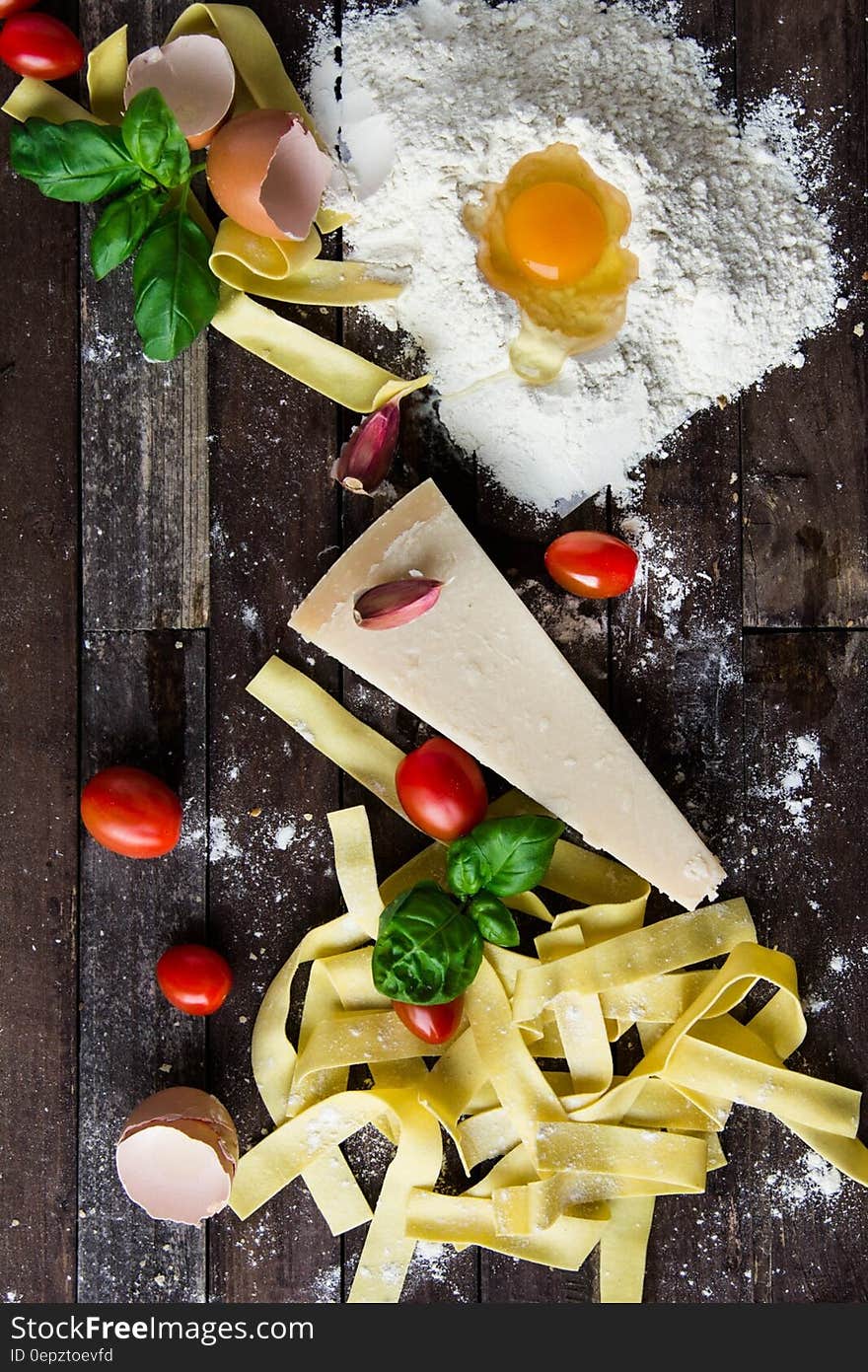 Pasta Tomatoes and Flour With Egg Shells on Table