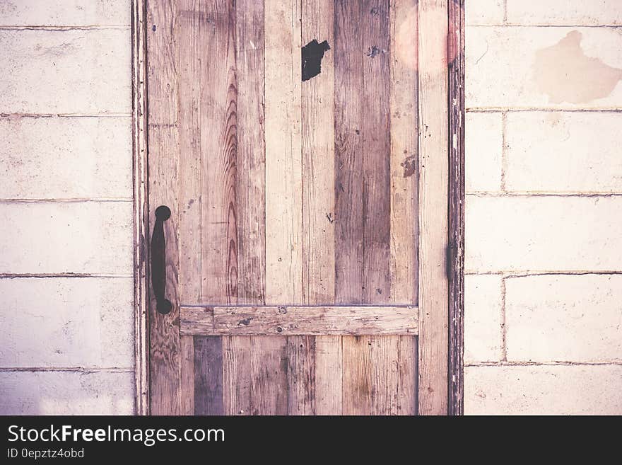 Close up of rustic wooden door on cement block wall.