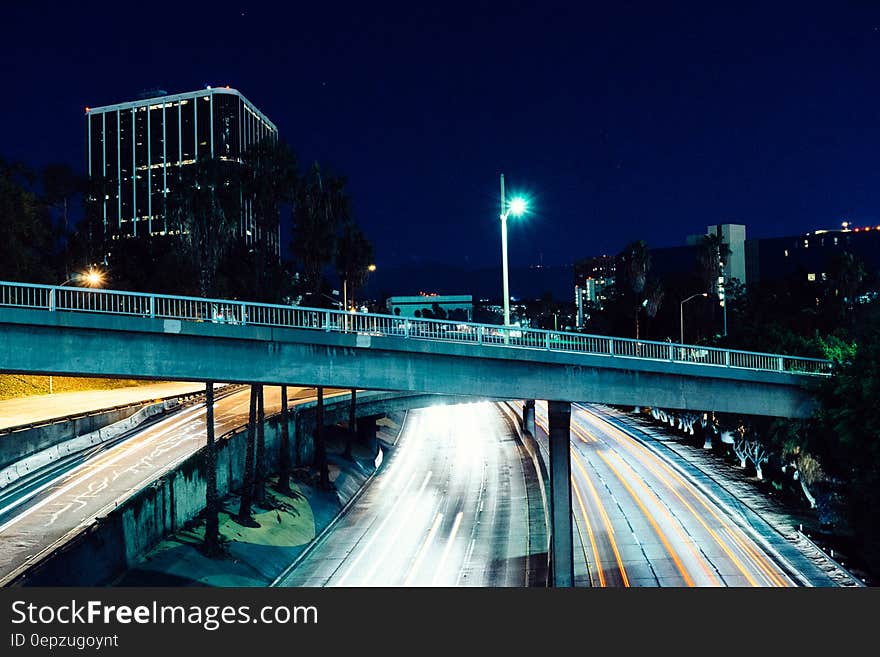 Blur of headlights and taillights on freeway under bridge through city at night. Blur of headlights and taillights on freeway under bridge through city at night.