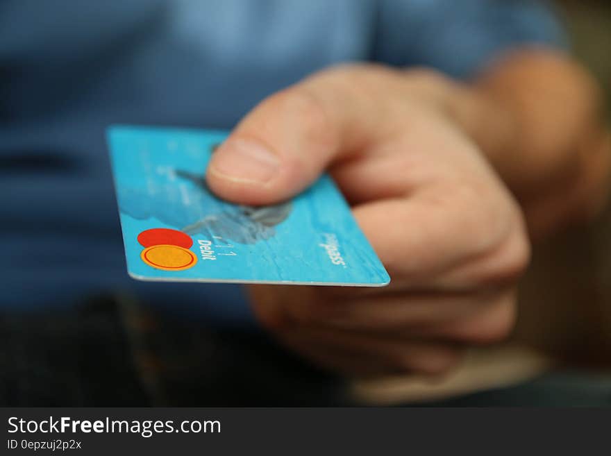 Close up of hand holding blue credit card. Close up of hand holding blue credit card.