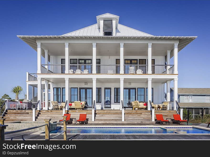 Exterior of luxury home with swimming pool on sunny day. Exterior of luxury home with swimming pool on sunny day.