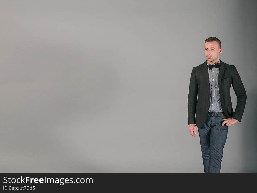 Studio portrait of man in in blue jeans with jacket and bow tie with copy space. Studio portrait of man in in blue jeans with jacket and bow tie with copy space.