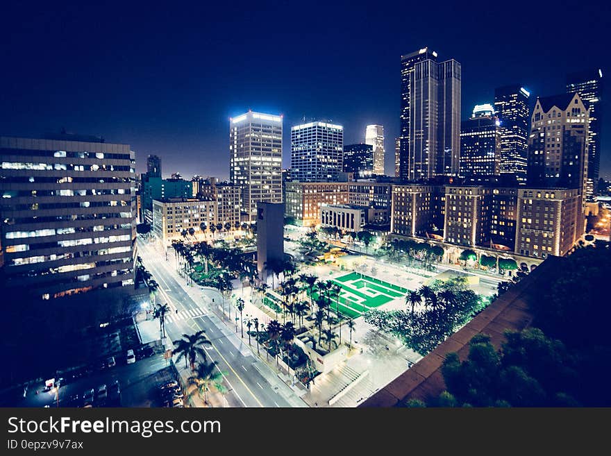 Modern city night scene from elevated view with plaza in foreground.