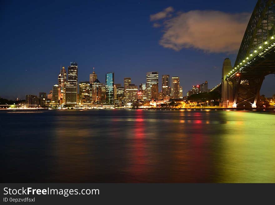 Panoramic Photography of Metropolis Next to Bridge during Night Time